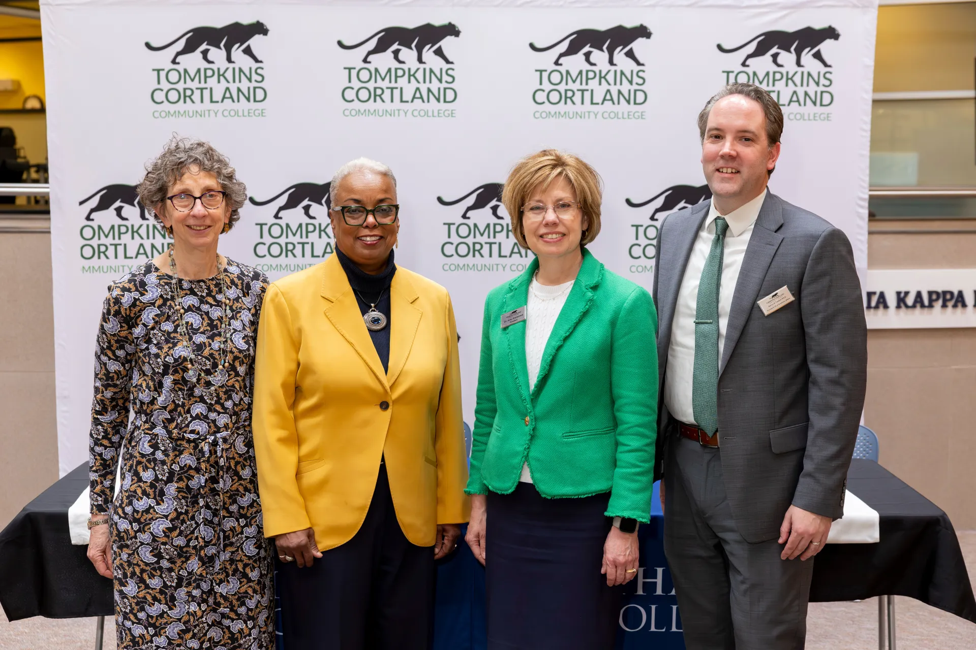 A group of people smile at a press conference.