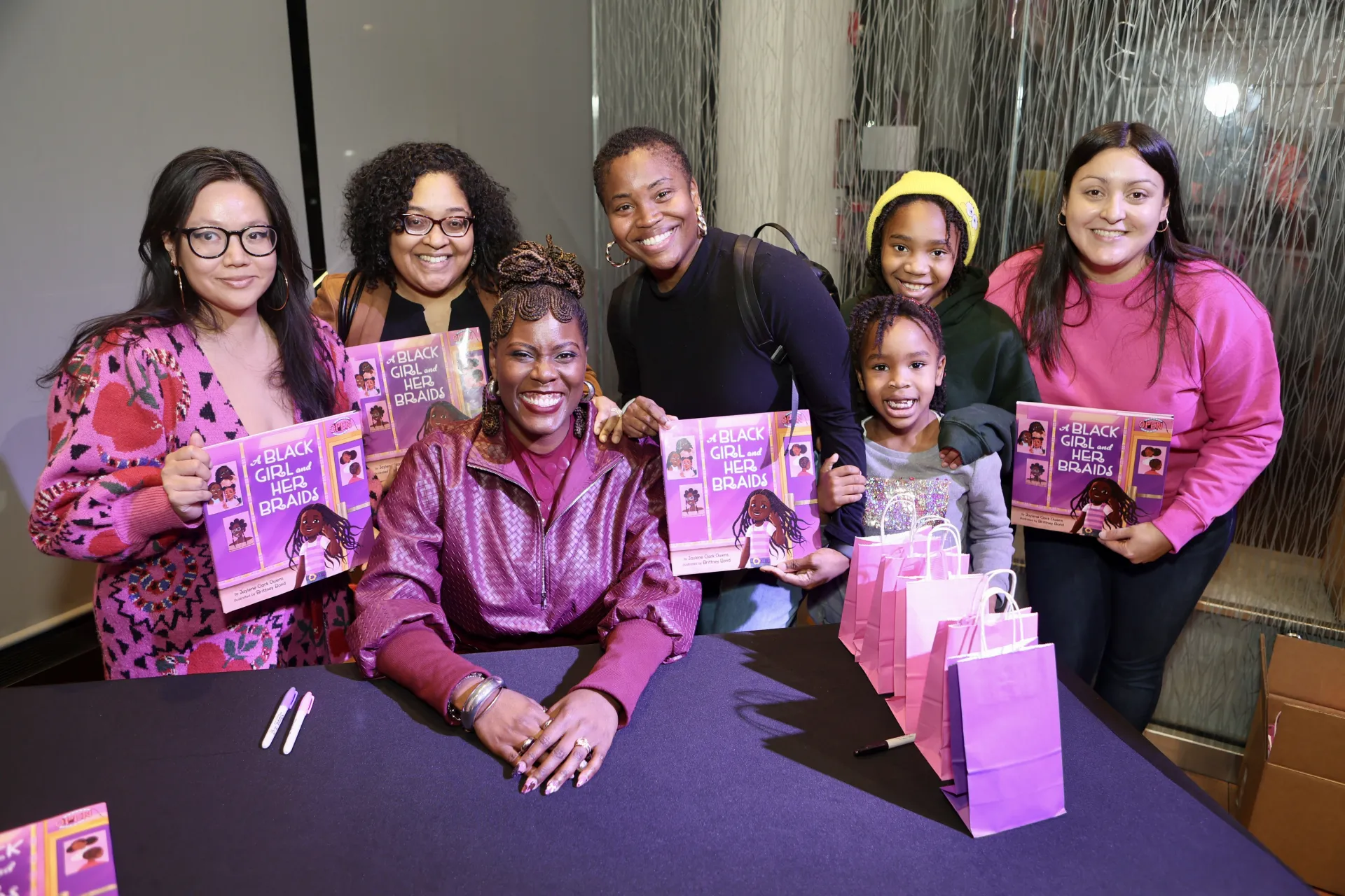 Fans and friends gather around author Jaylene Clark Owens '10 at a book event.
