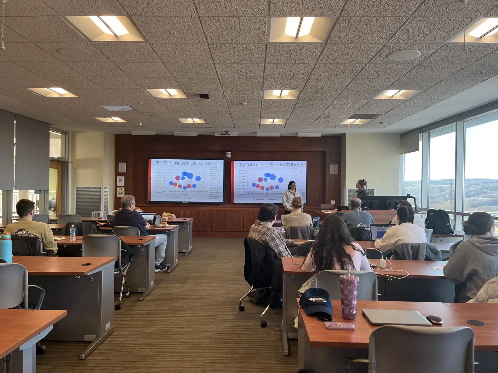 A classroom with students facing the front board for a presentation.