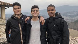 three students in front of a mountain in Italy