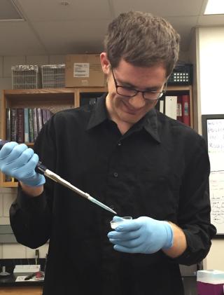 student pipetting into a small tube