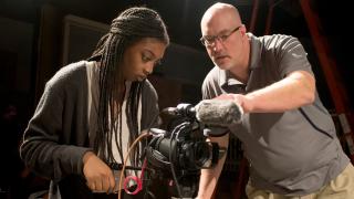 Dr. James Rada teaching a student to operate a camera.