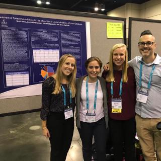 Three students and one faculty member are standing in front of their poster titled "Treatment of Speech Sound Disorders as a Function of Lexical Variables: A Stimuli Database."