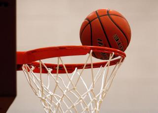 Basketball on a hoop rim.