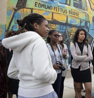 students in front of a mural that reads "Edmund Pettus Bridge"