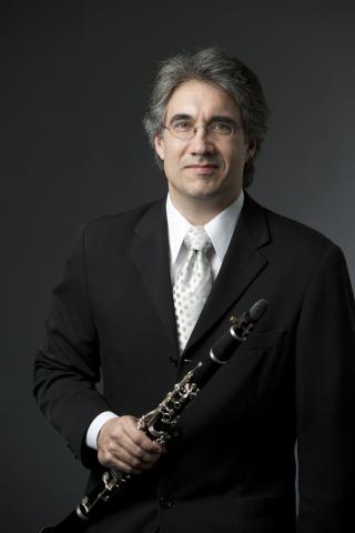 Person wearing suit holding clarinet