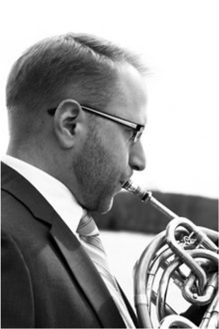 Profile view photo of man playing french horn