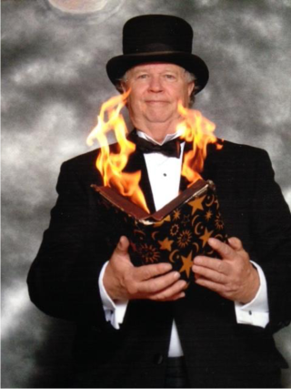 Picture of a man in a tuxedo and top hat, holding a flaming book