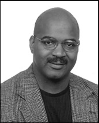 Headshot of man with glasses and a moustache