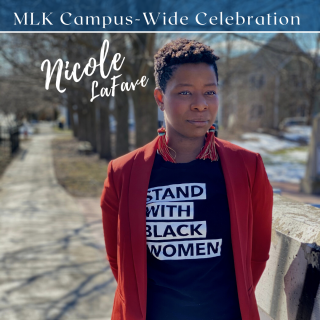 Nicole is standing to the side of an Ithaca street looking off camera. She is wearing a red blazer with a dark blue shirt underneath that reads "Stand with Black Women" on the front.  Her curly hair is cropped short and she is wearing long, red, tassel earrings. Above her head are the words "MLK Campus-Wide Celebration" and next to her reads "Nicole, LaFave"