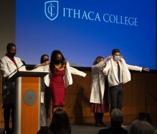 students receiving white coats