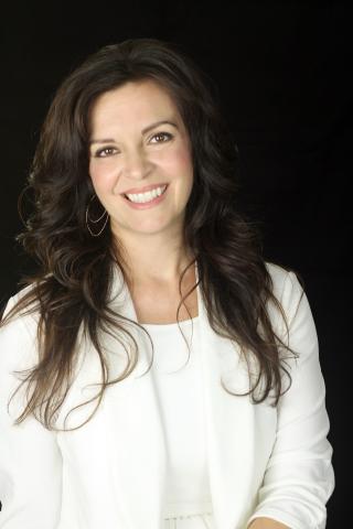 Dawn Pierce is pictured in a white suite and long black hair.