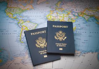 Image of two US passports on a colorful world map