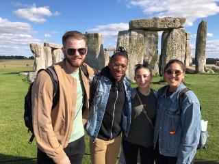Four Ithaca College students posing in front of Stonehenge