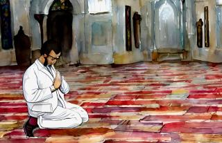 a man in a white coat is kneeling and praying in a mosque