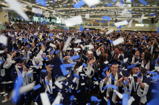 Image of students celebrating at Commencement 2023 with confetti falling inside the Athletics and Events Center Glazer Arena