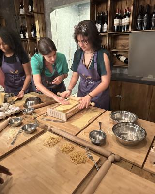 A student rolling pasta dough in a pasta-making class in Rome