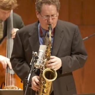 Caucasian male playing a saxophone