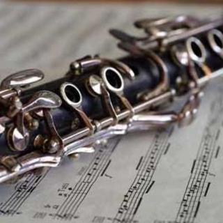 Closup of a clarinet resting on a piece of sheet music.