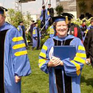 Woman in ceremonial academic cap and gown.