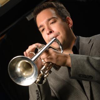 Picture of person in suit playing trumpet