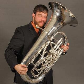 Man in a suit with a tuba