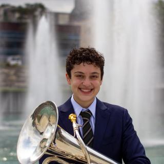 Picture of Isaac Schneider holding a Euphonium