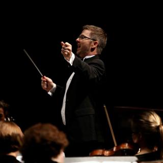 Man in a suit conducting