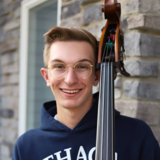 man with Ithaca College sweatshirt holding double bass