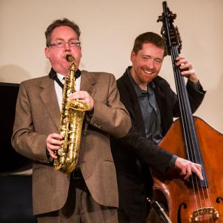 Two male professors playing saxophone and upright bass.