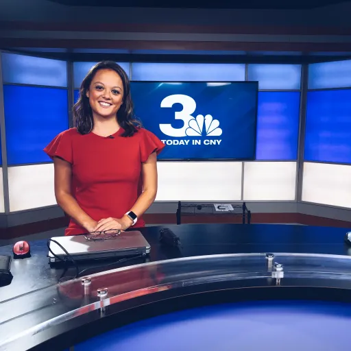 Journalism alum Amanda Chin sitting at news desk