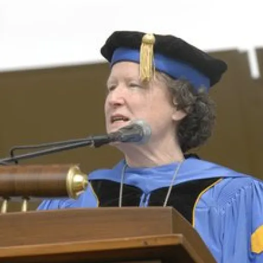 Woman in ceremonial academic cap and gown.