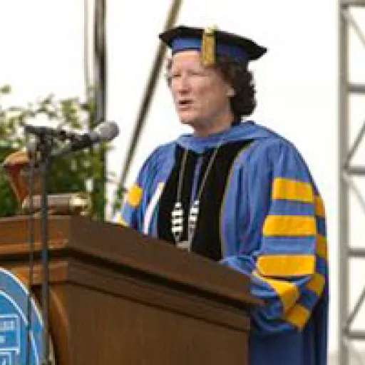 Woman in ceremonial academic cap and gown.