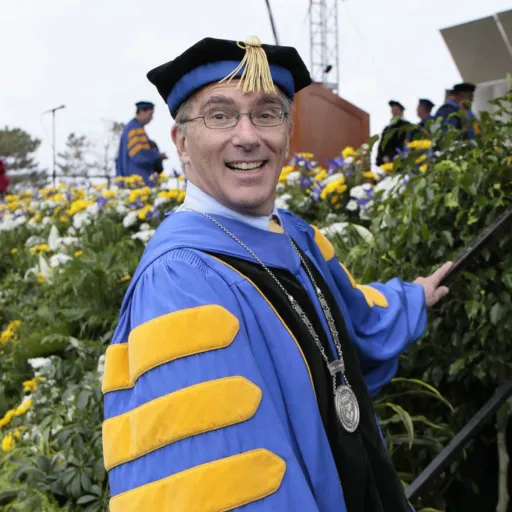 In academic cap and gown. 