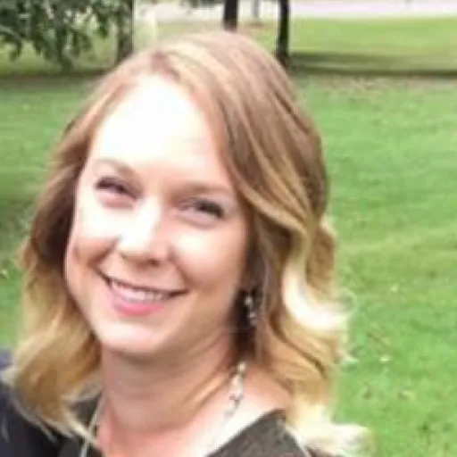 Kelsey smiling with trees and grass in the background