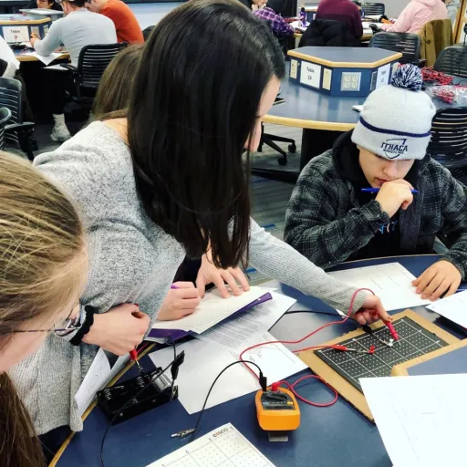 A student helps others in the classroom