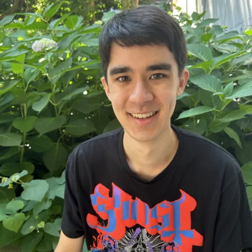 person sitting in front of tree smiling