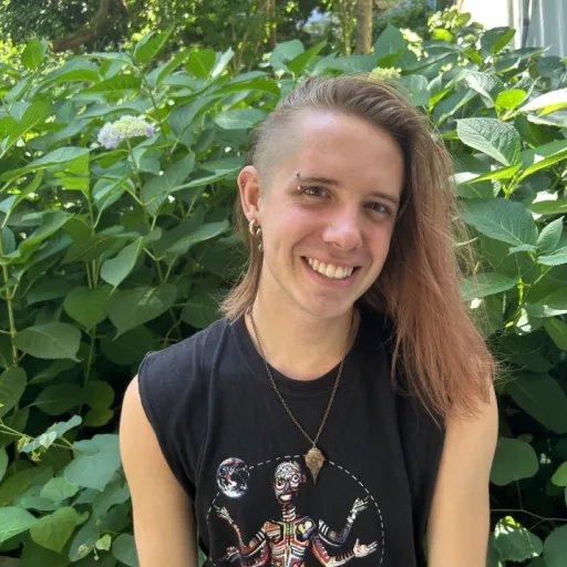 person sitting in front of tree smiling