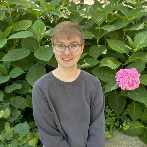 person sitting in front of tree smiling