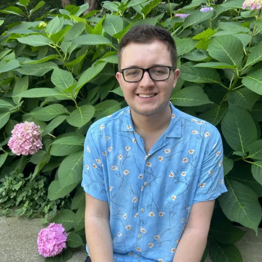 person sitting in front of tree smiling