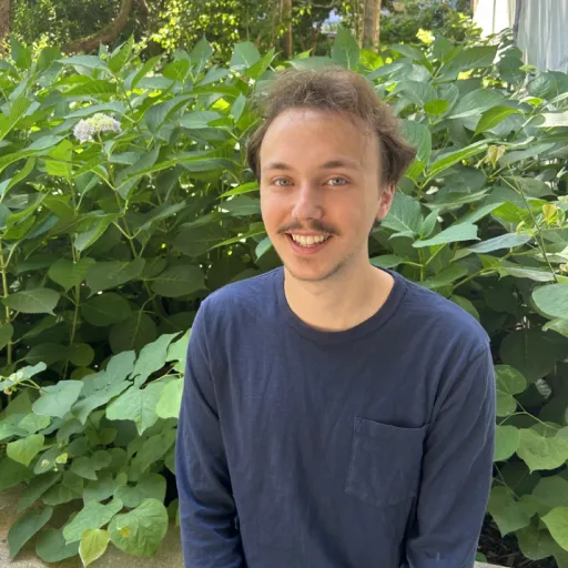 person sitting in front of tree smiling