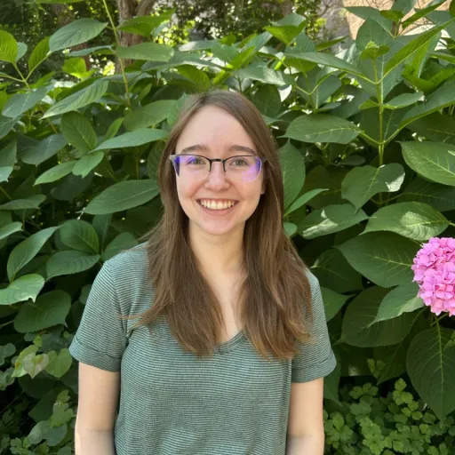 person sitting in front of tree smiling