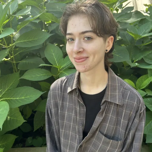 person sitting in front of tree smiling