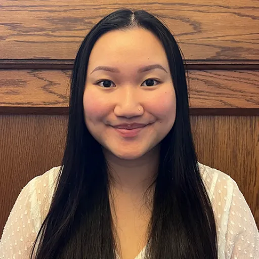 A woman in front of a wood paneling background